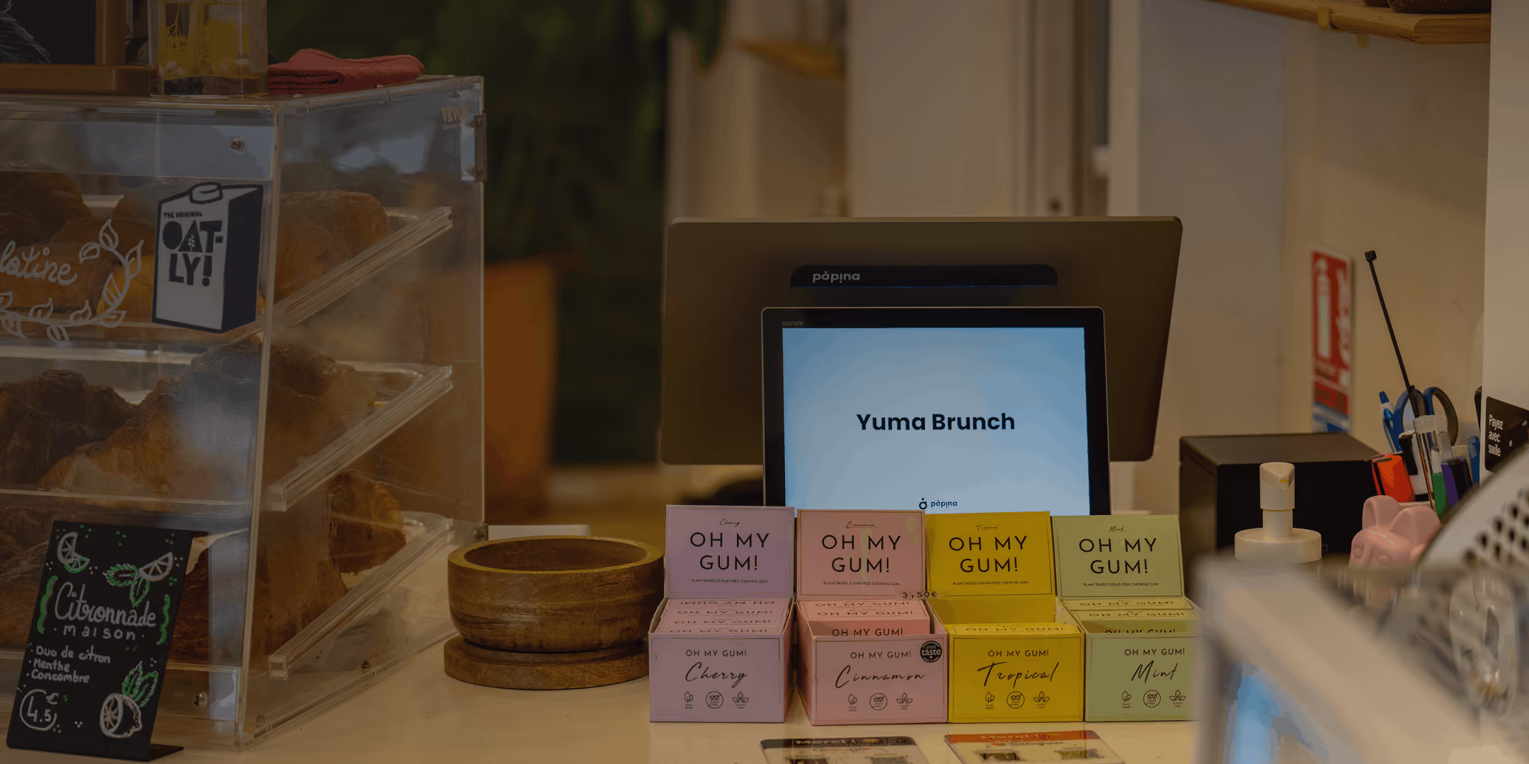 Caisse enregistreuse Popina dans une boutique à Toulouse avec présentoir de chewing-gums Oh My Gum et croissants dans une vitrine.