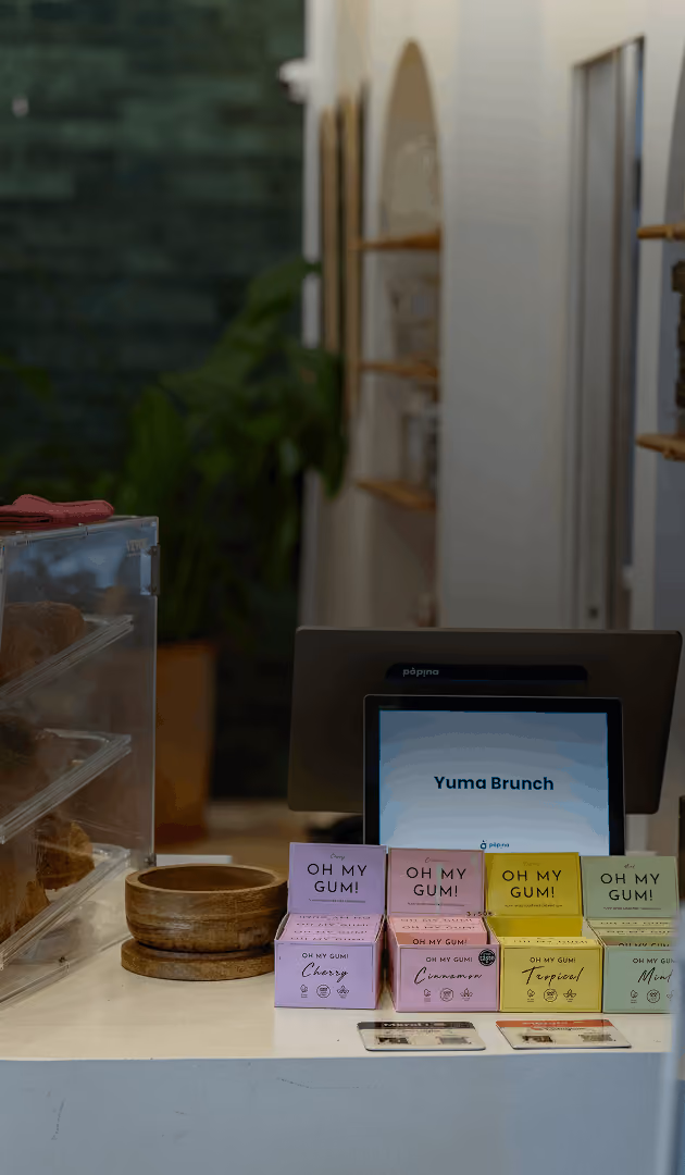Une caisse enregistreuse de la marque Popina à Toulouse affichant Yuma Brunch et des boîtes colorées de gommes Oh My Gum.