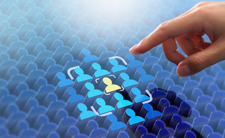 Hand pointing at a highlighted yellow figure among a group of blue human icons representing selection or recruitment.