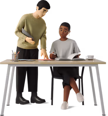 Tutor standing and pointing at book while student sits reading at desk with supplies.