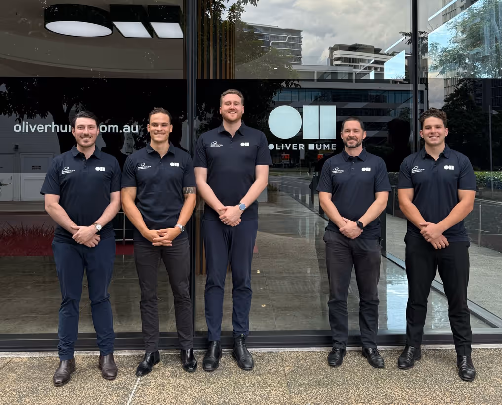 Five men standing in front of a Oliver Hume labelled glass door