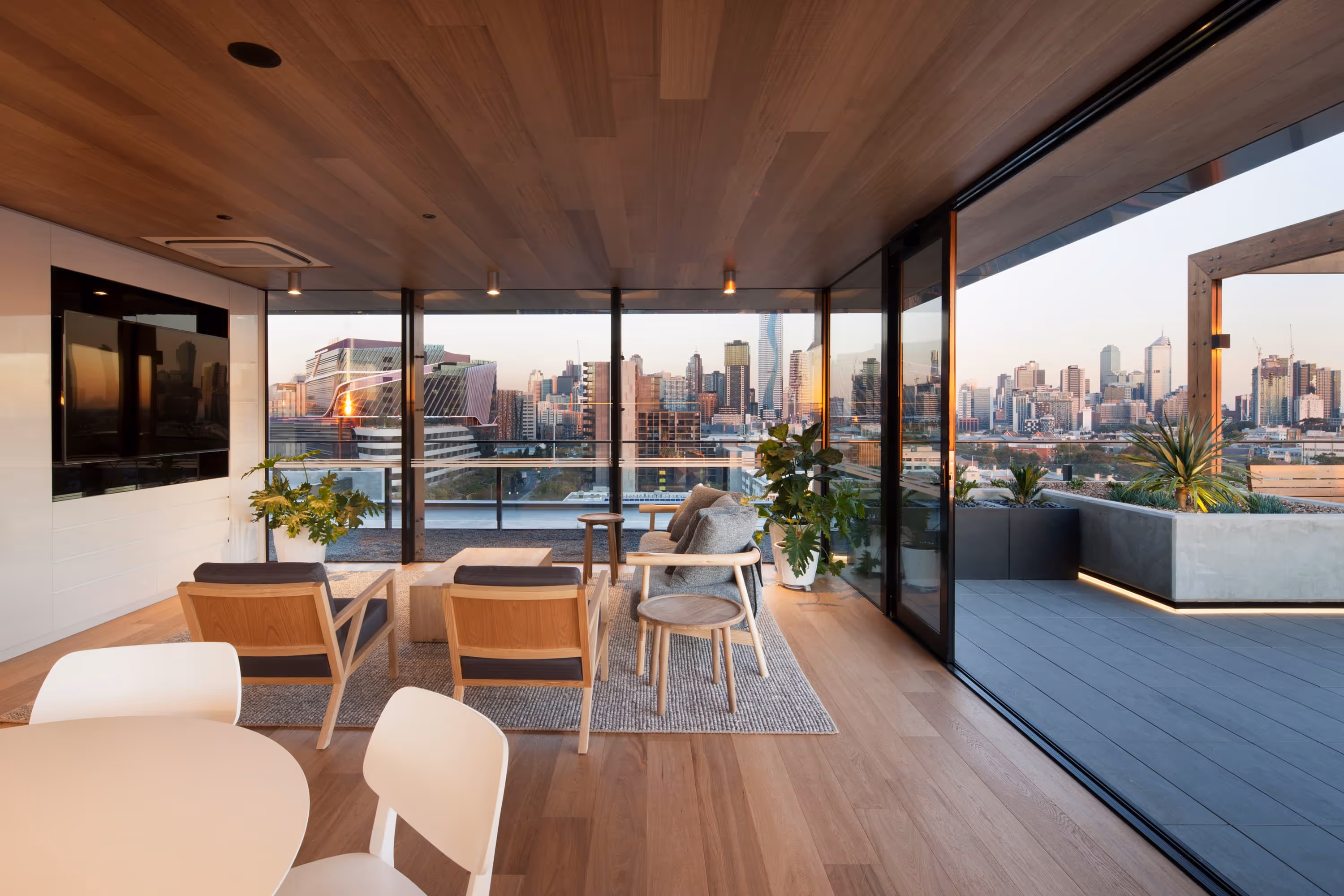 Bright lounge room with floor-to-ceiling windows and panoramic views of the city skyline.