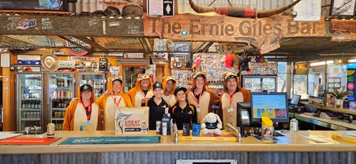 Group of people standing behind a bar.
