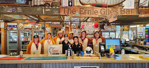 Group of people standing behind a bar.