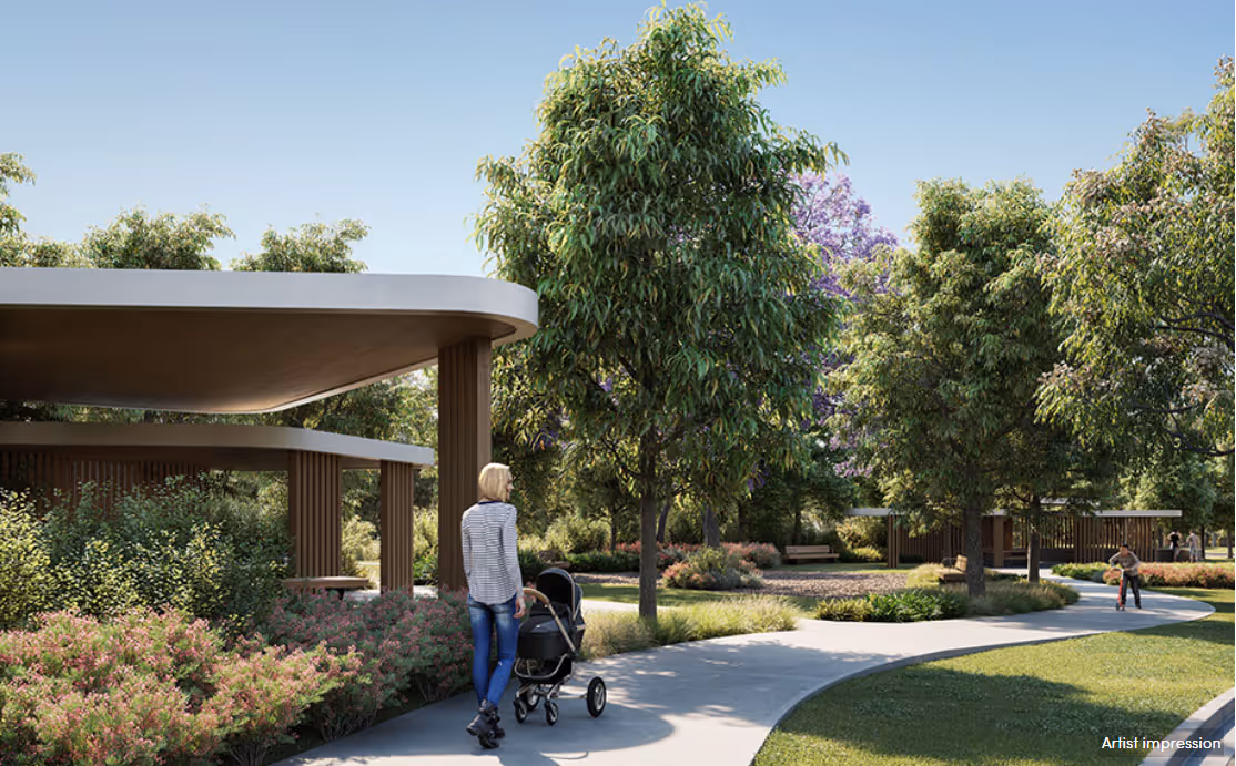 Artist impression of a landscaped community park with modern shelters, lush trees, and walking paths, featuring a woman pushing a pram along the curved pathway