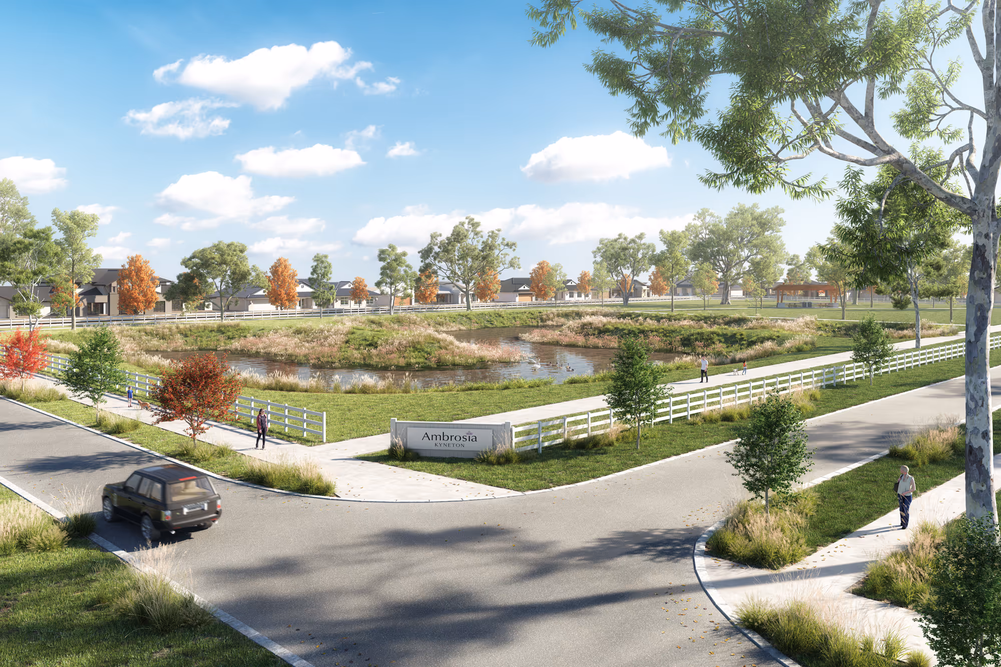 A peaceful residential community entrance with a sign reading “Ambrosia Kyneton,” surrounded by white fencing, walking paths, a pond, and autumn-coloured trees under a bright blue sky.