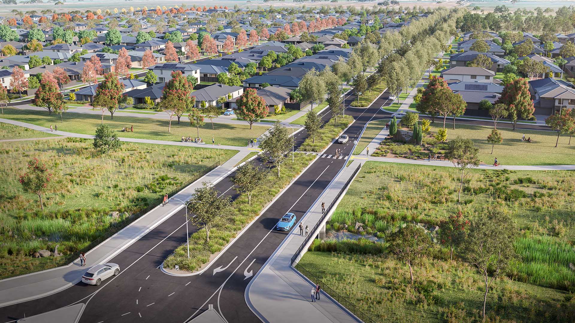 High-angle rendered view of a planned suburban street running through a green space, flanked by new single-family homes with dark roofs. The street features a central tree-lined median and bridges over grassy, natural drainage areas with people walking.