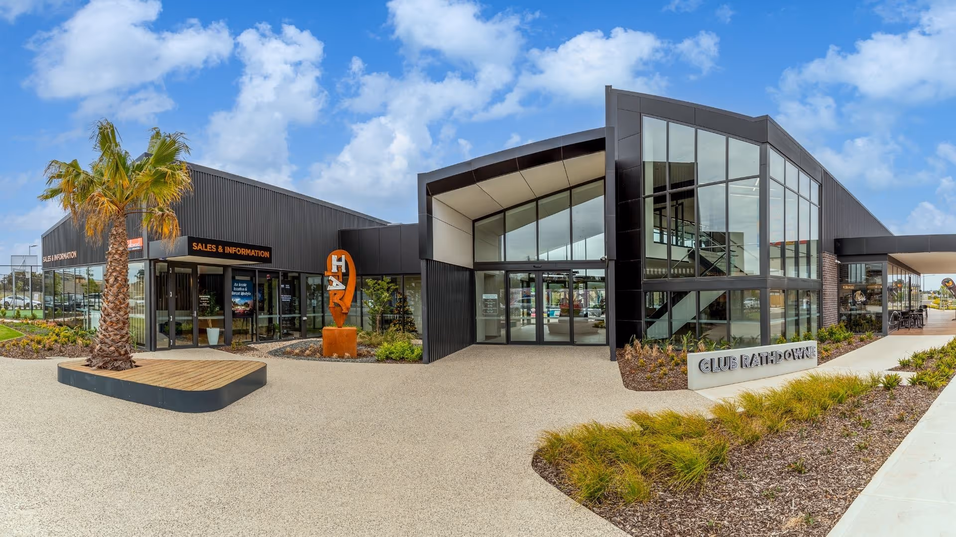 Sales & information centre with modern black facade and landscaped entrance.