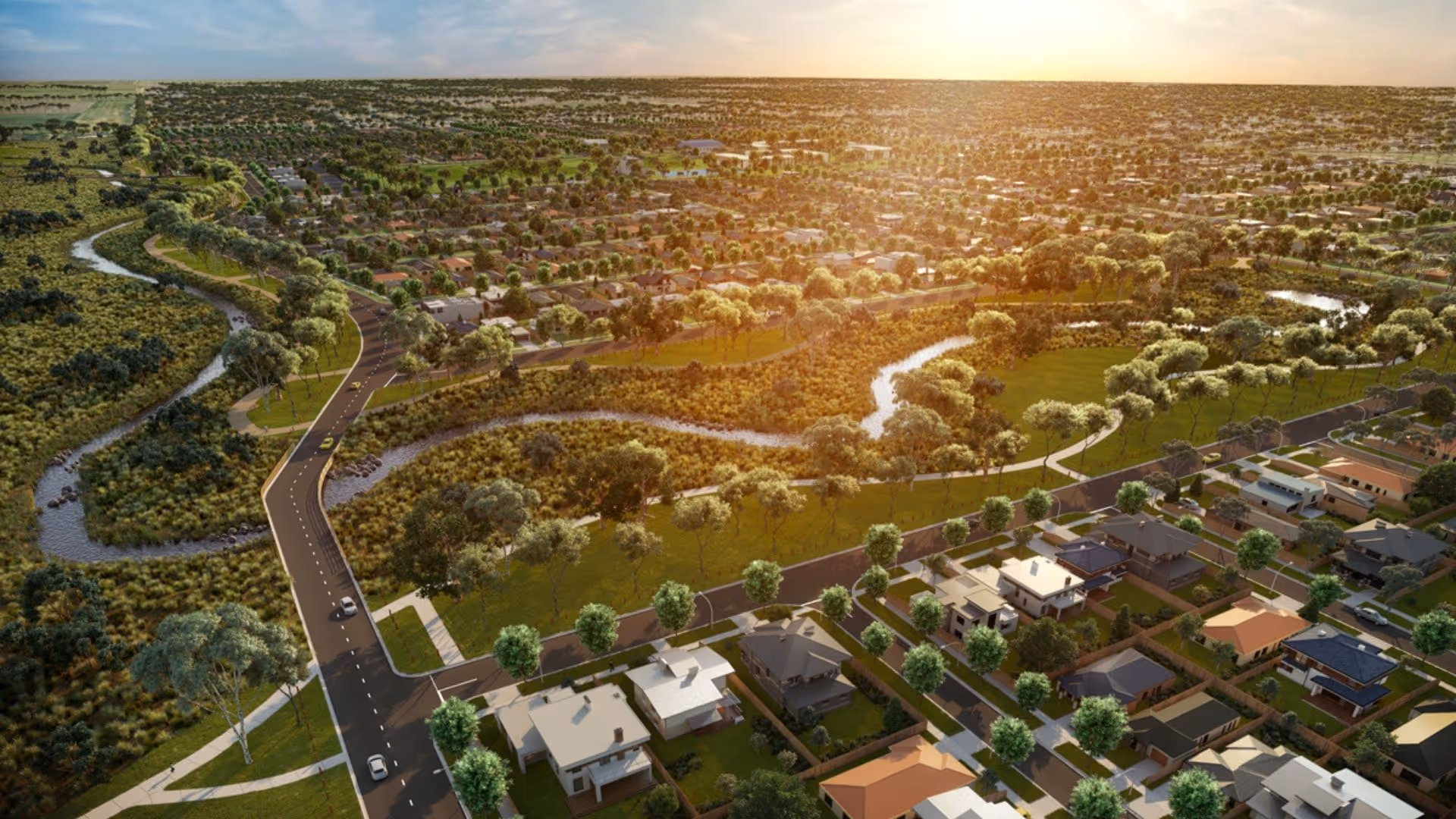 Aerial view of a masterplanned community with winding waterways, parks and surrounding homes at sunset.