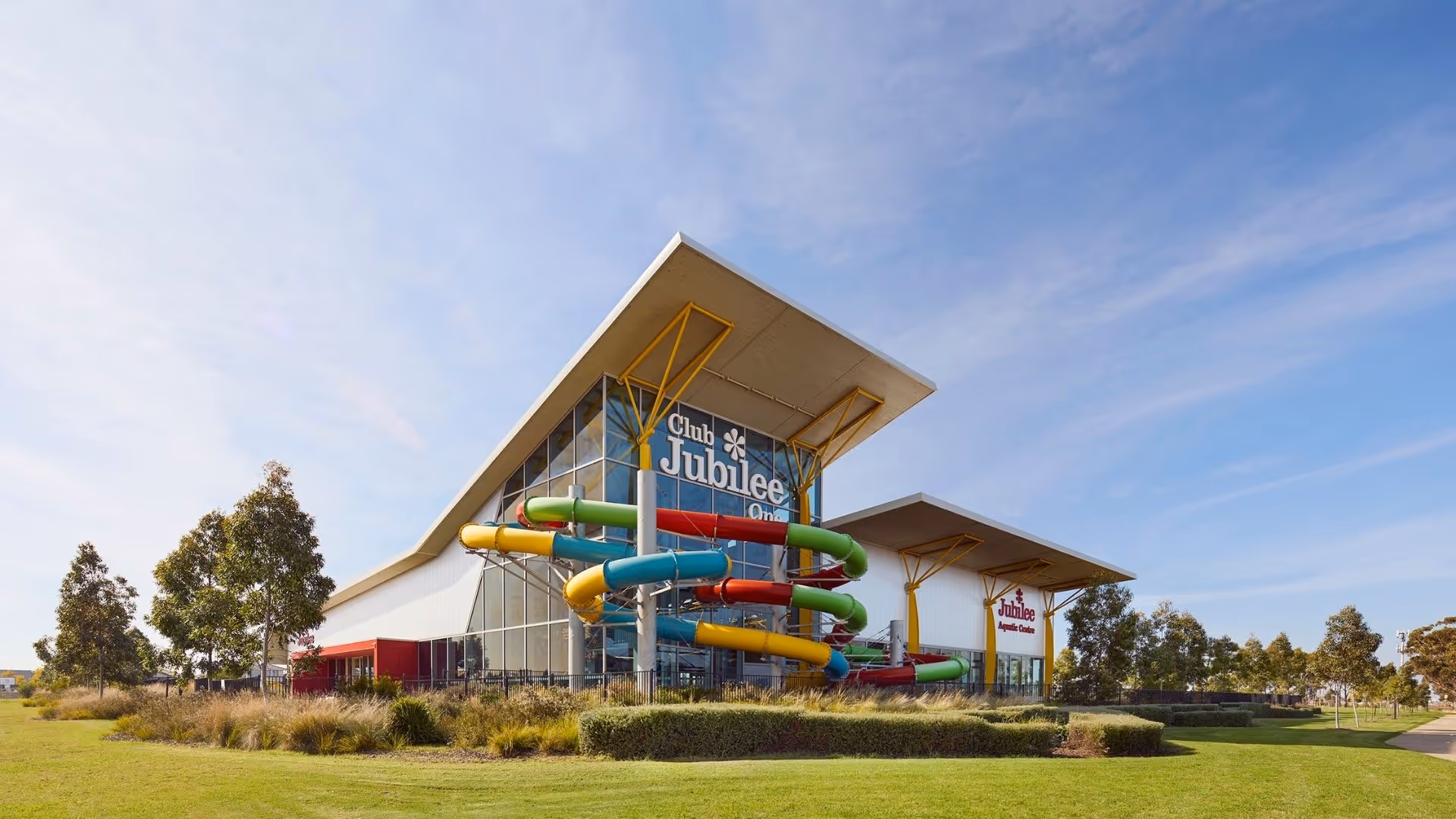 Club Jubilee building with large colorful water slides wrapping around the exterior on a sunny day.