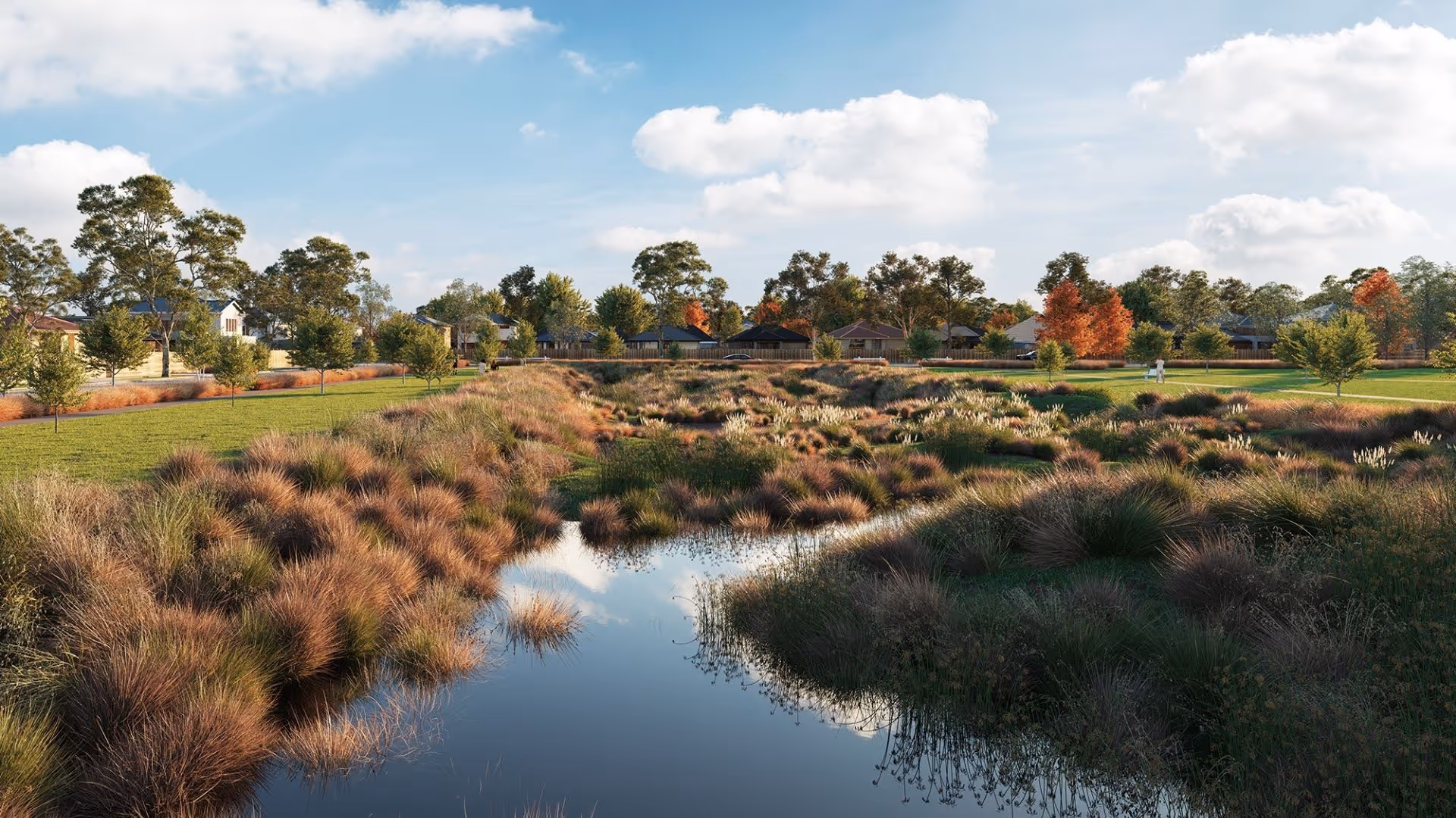 Rendered image of a natural creek or waterway filled with tall, reddish-brown grasses and reeds, reflecting the sky. On the banks, a green lawn separates the waterway from suburban homes visible in the background beneath a blue, cloudy sky.