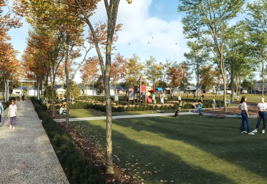 A rendered view of a landscaped suburban park with a large green lawn, a pathway lined with mature trees showing autumn colors, and a distant children's playground. Several people are visible enjoying the park, walking, sitting, and playing.