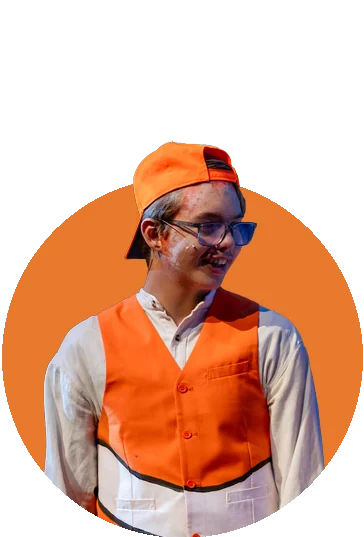 A smiling Tapestry actor in an orange cap and clownfish vest in Finding Nemo Jr.