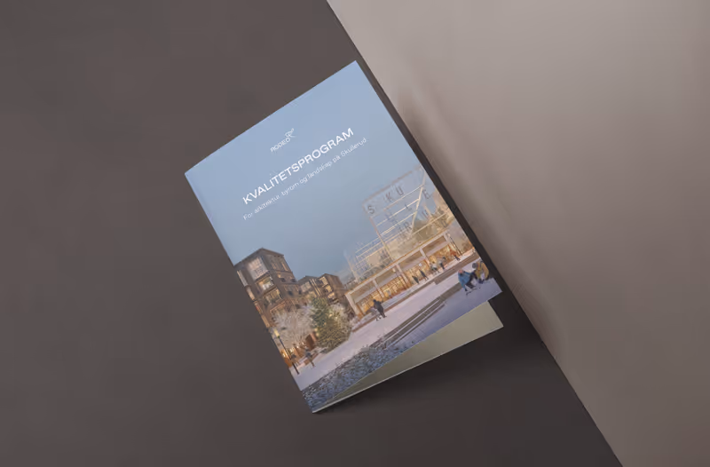 Brosjyre med tittelen «KVALITETSPROGRAM» som viser en arkitektvisualisering av et moderne bygningskompleks med mennesker som går ved et utendørs torg.