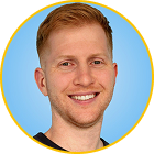 Smiling young man with short reddish blonde hair and light skin against a blue background.