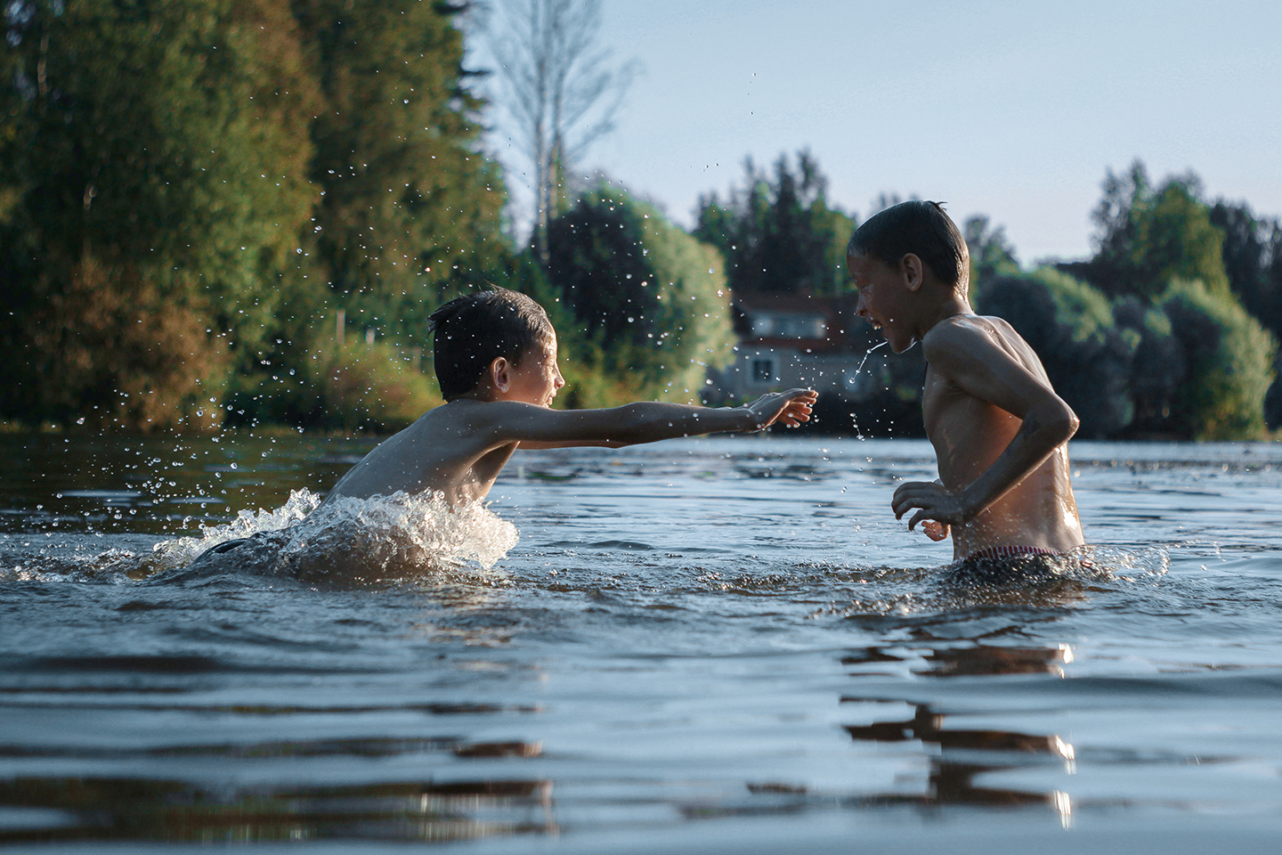 Zwei Kinder spielen lachend im Wasser des Auesees in Wesel beim Neujahrsschwimmen des Rotary Clubs