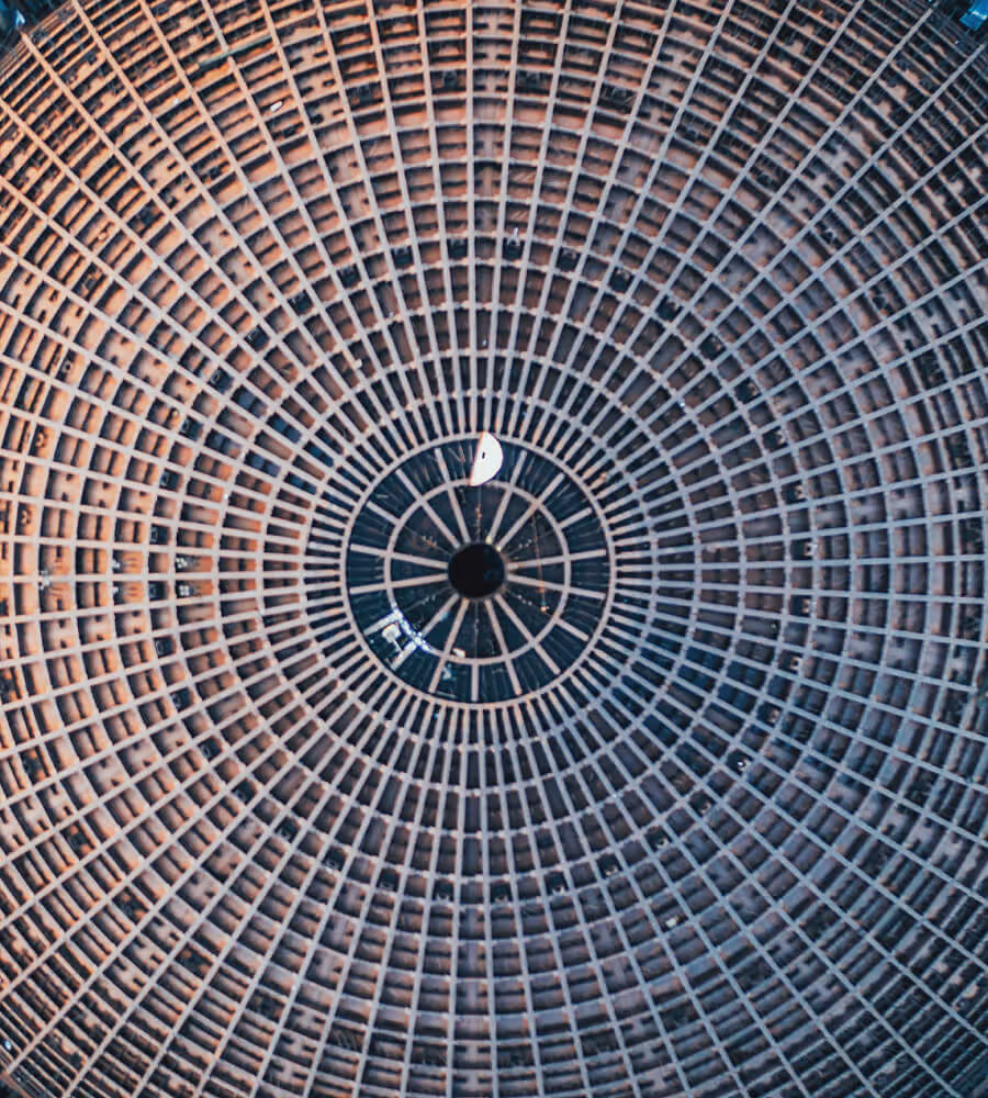 Symmetrical circular ceiling structure with a grid pattern radiating from a central point.