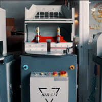 آلة صناعية مزودة بلوحة تحكم ورافعات في ورشة العمل.