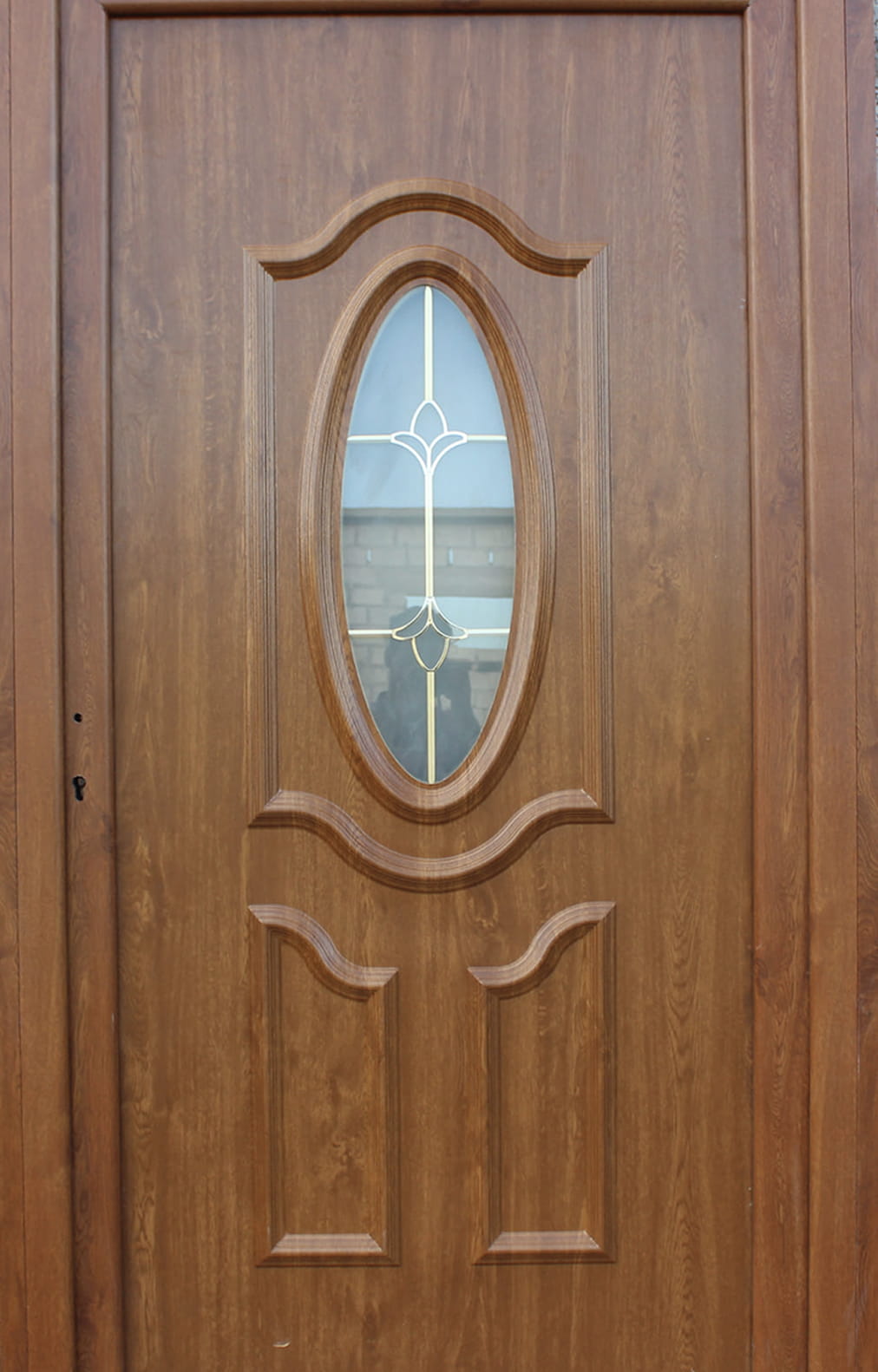 باب خشبي wpc مع نافذة زجاجية بيضاوية مزخرفة تتميز بتصميم معدني على شكل زهور.