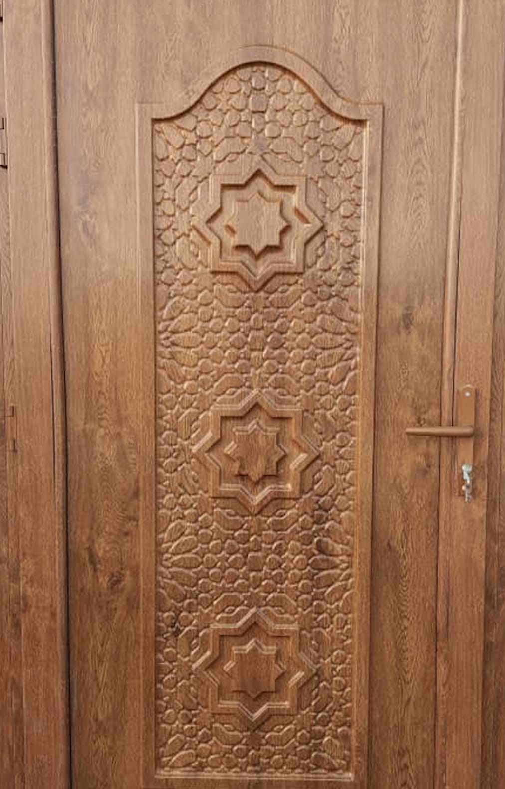 باب خشبي wpc بثلاثة أنماط نجمية هندسية منحوتة كبيرة محاطة بزخارف نباتية ومقبض باب بمفتاح.