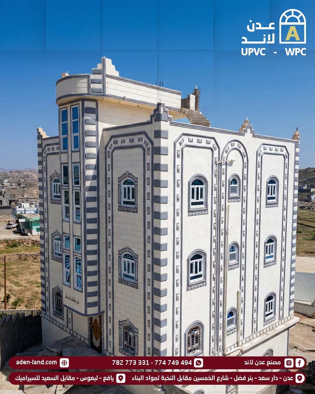 مبنى أبيض متعدد الطوابق مع لمسات رمادية مزخرفة ونوافذ عديدة تحت سماء زرقاء صافية. upvc