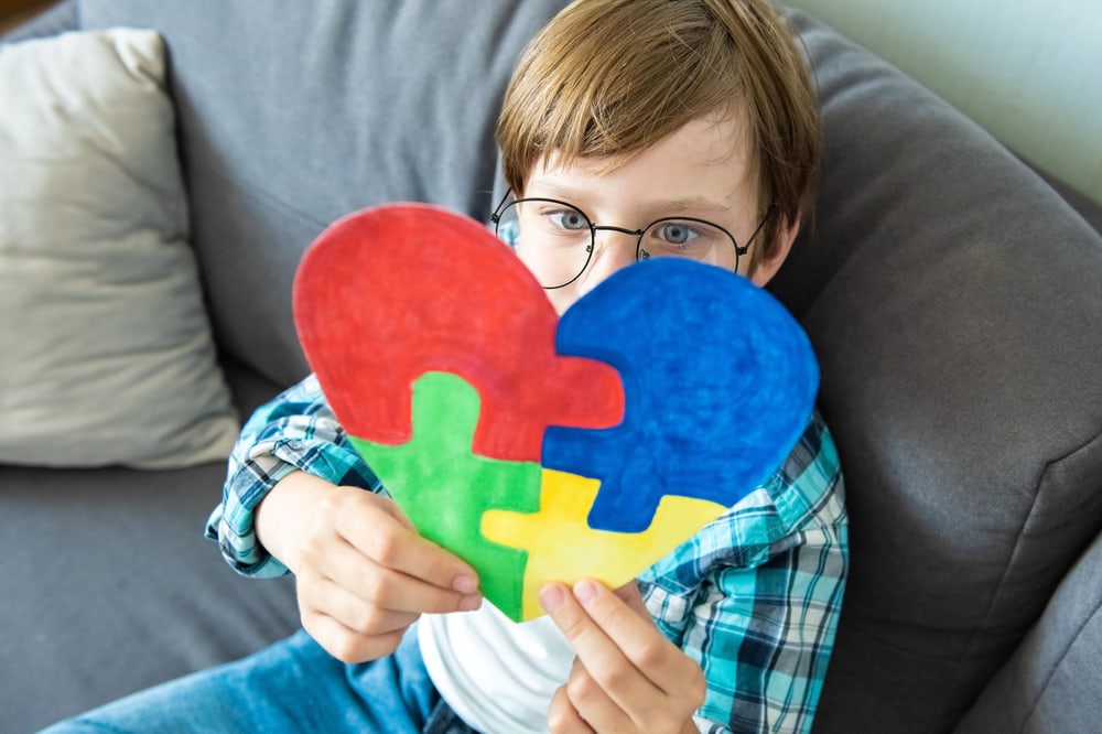 Kind mit Continova Logo aus Papier.