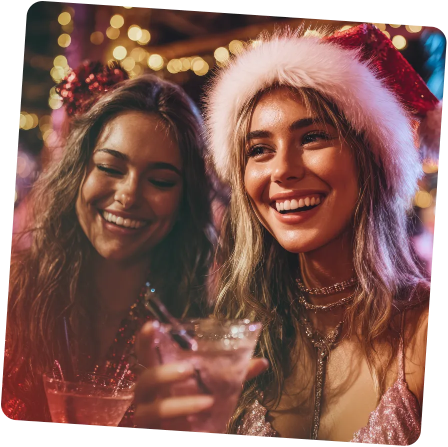 a group of women wearing santa hats and holding drinks