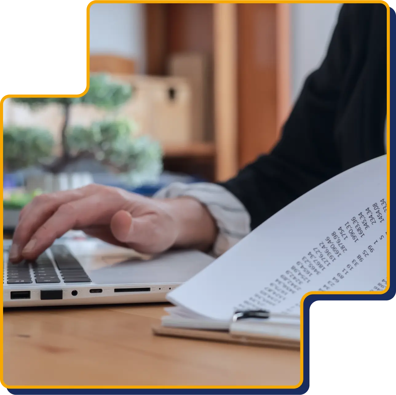 Hand som arbetar vid dator med löneunderlag, som symboliserar löneadministration och lönetjänster.