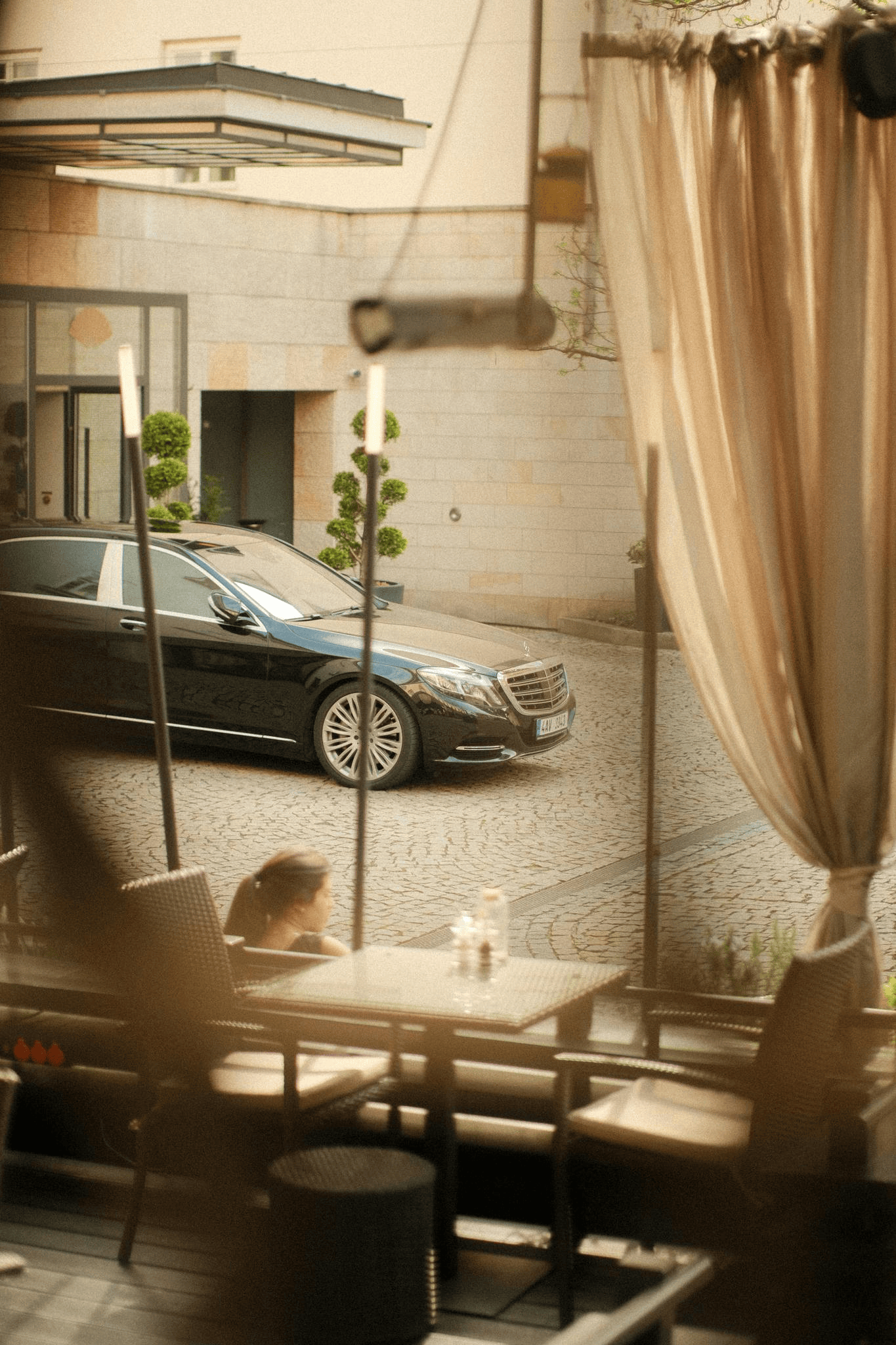 Luxury chauffeur vehicle parked outside a fine-dining restaurant in Cape Town.
