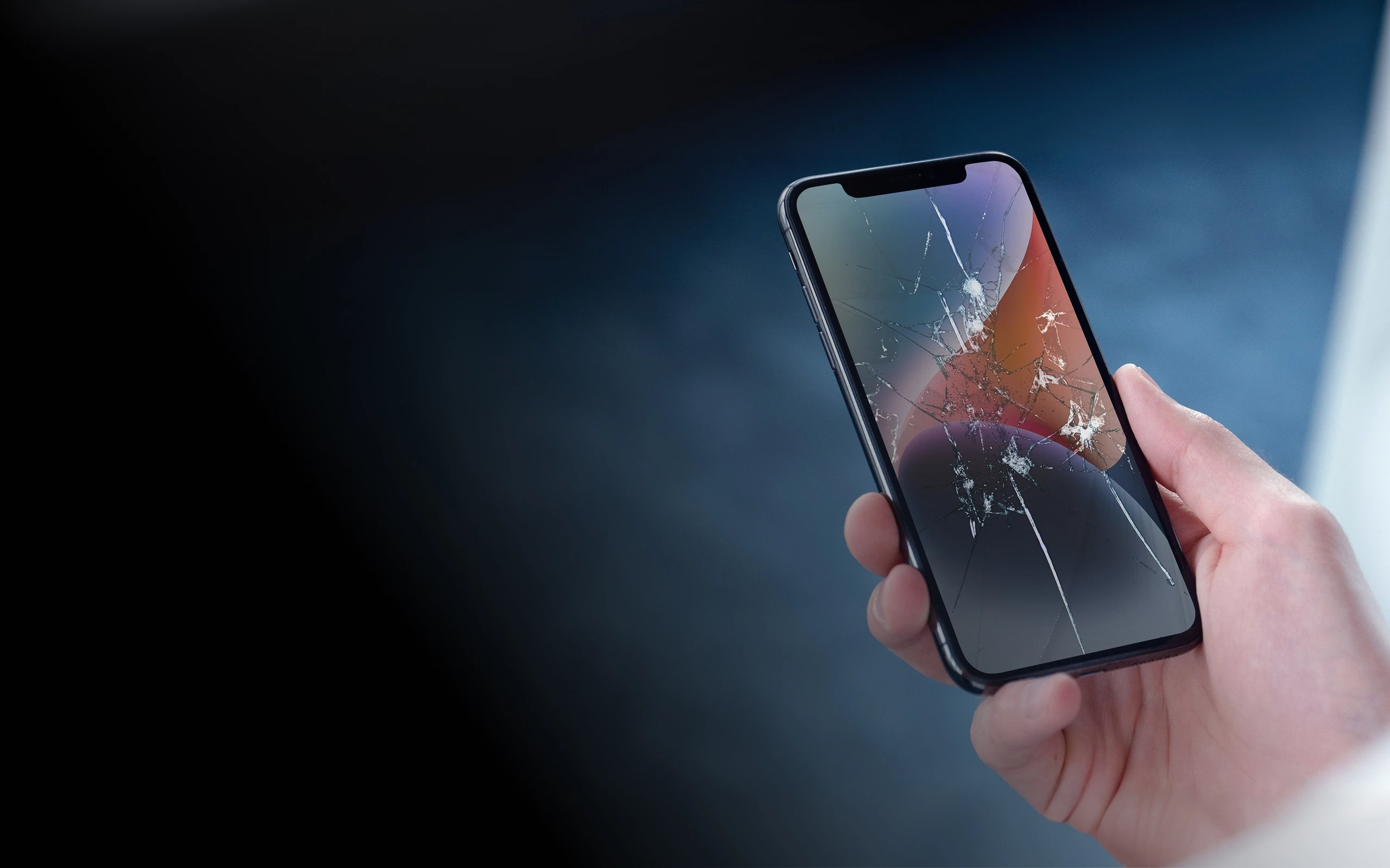 Hand holding a smartphone with a shattered screen ready for CPR screen replacement