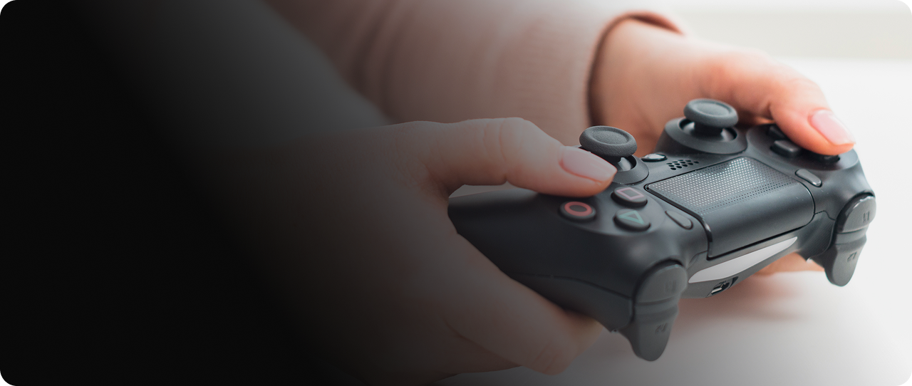 Person holding a black game controller for CPR common game console repair issues