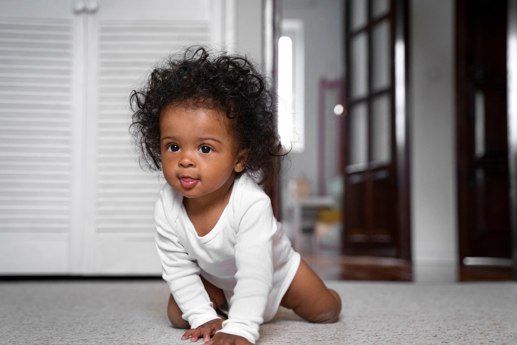 Adorable infant crawling on the floor.