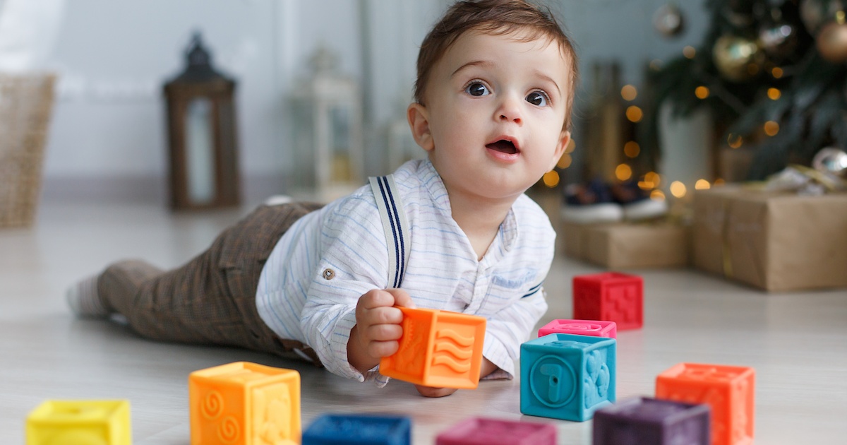 cute baby with toys on the floor