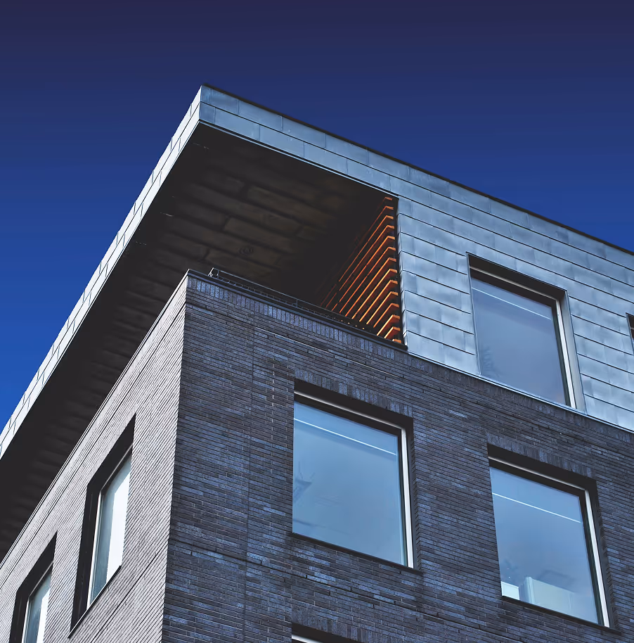 Zeitgemäßes Mehrfamilienhaus vor blauem Himmel