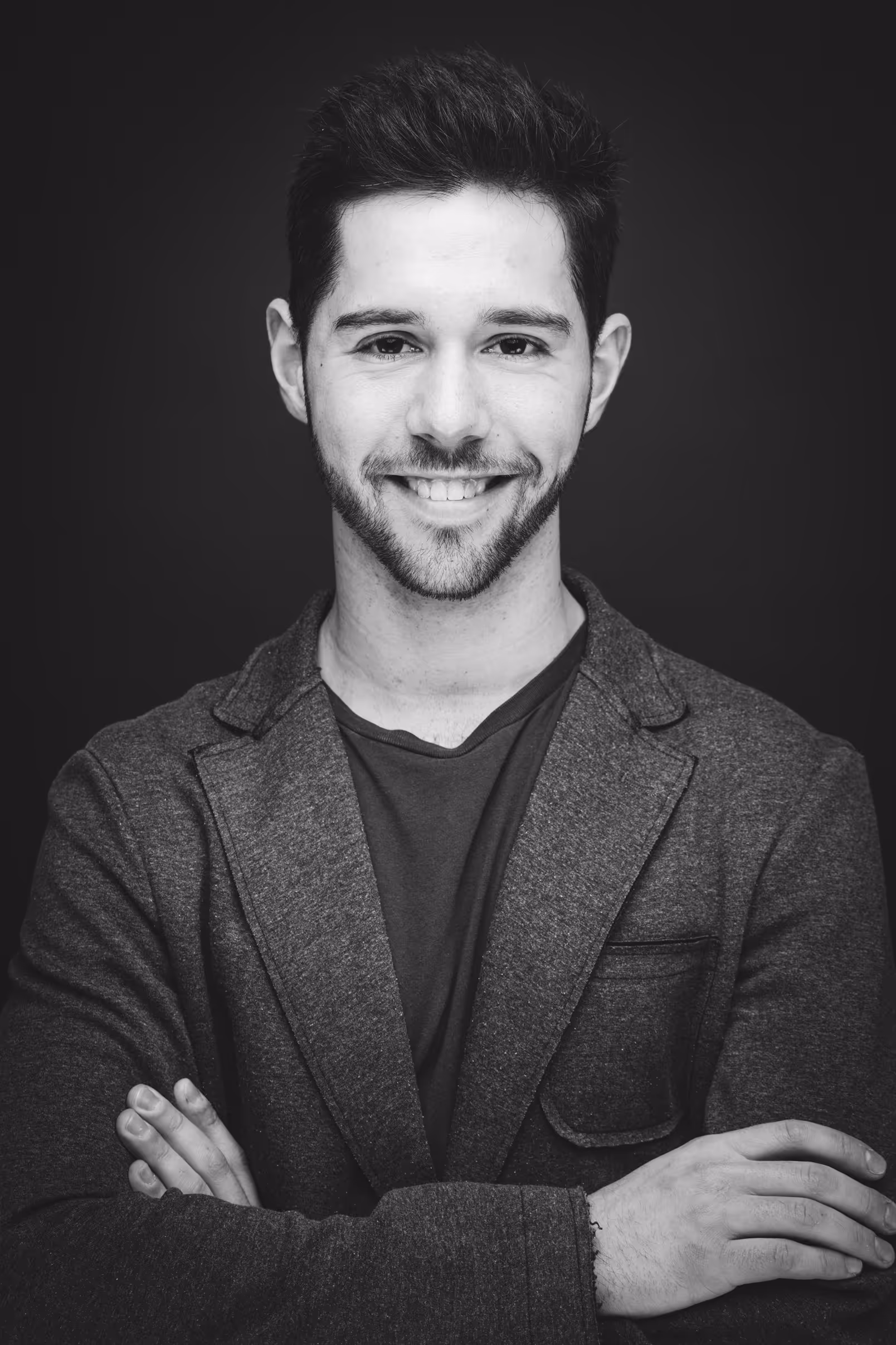 Felix Krotz im Anzug lächelt mit verschränkten Armen in die Kamera