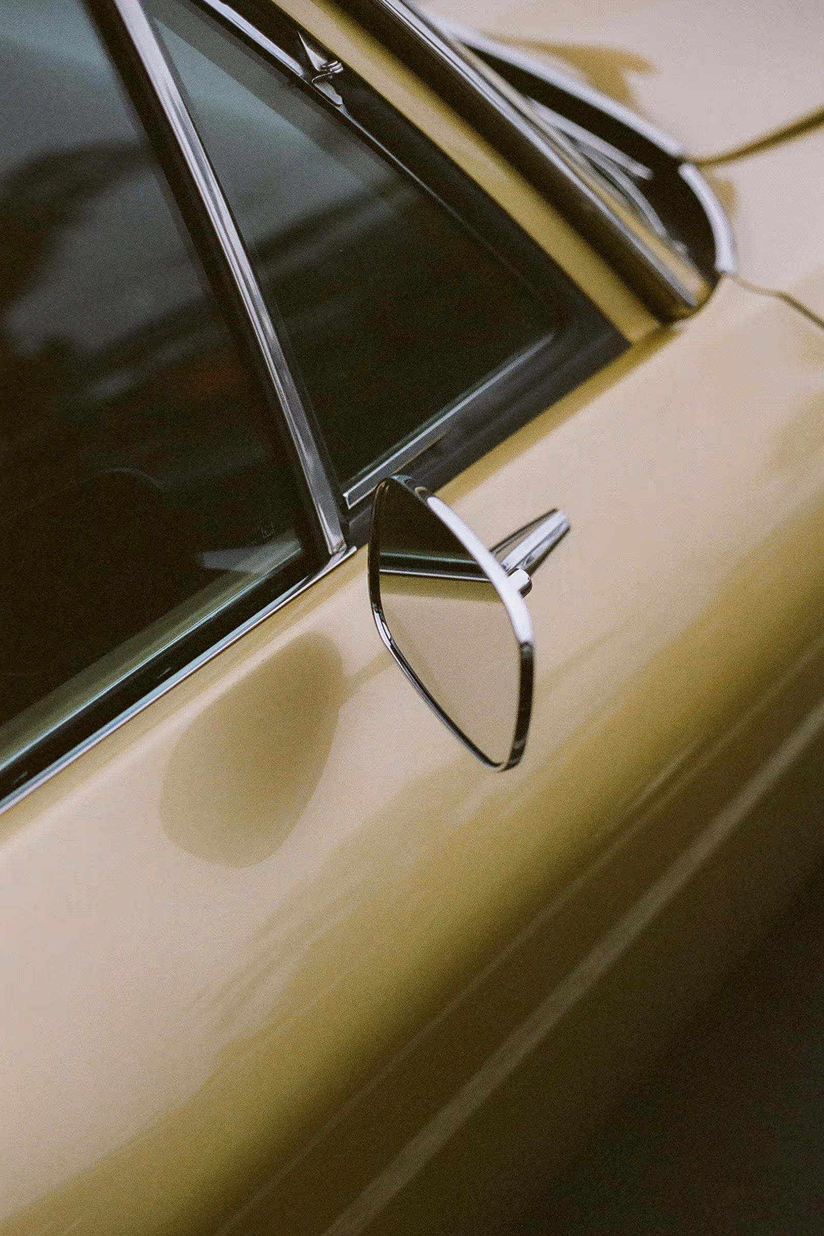 Detailaufnahme eines eleganten Autospiegels an einem hellen Fahrzeug