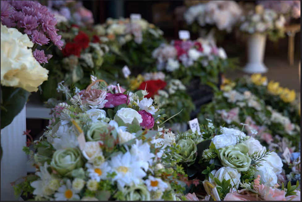 Close-up of assorted colorful floral arrangements displayed on tables in a flower shop.