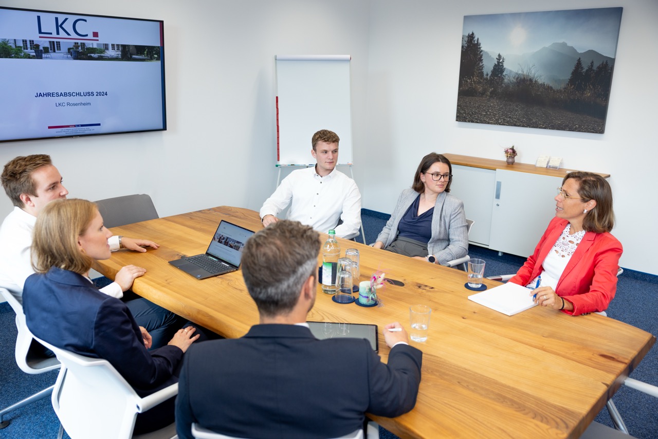 Mehrere Personen sitzen in einem Besprechungsraum und unterhalten sich.