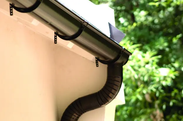 Rounded gutter in black attached to a house
