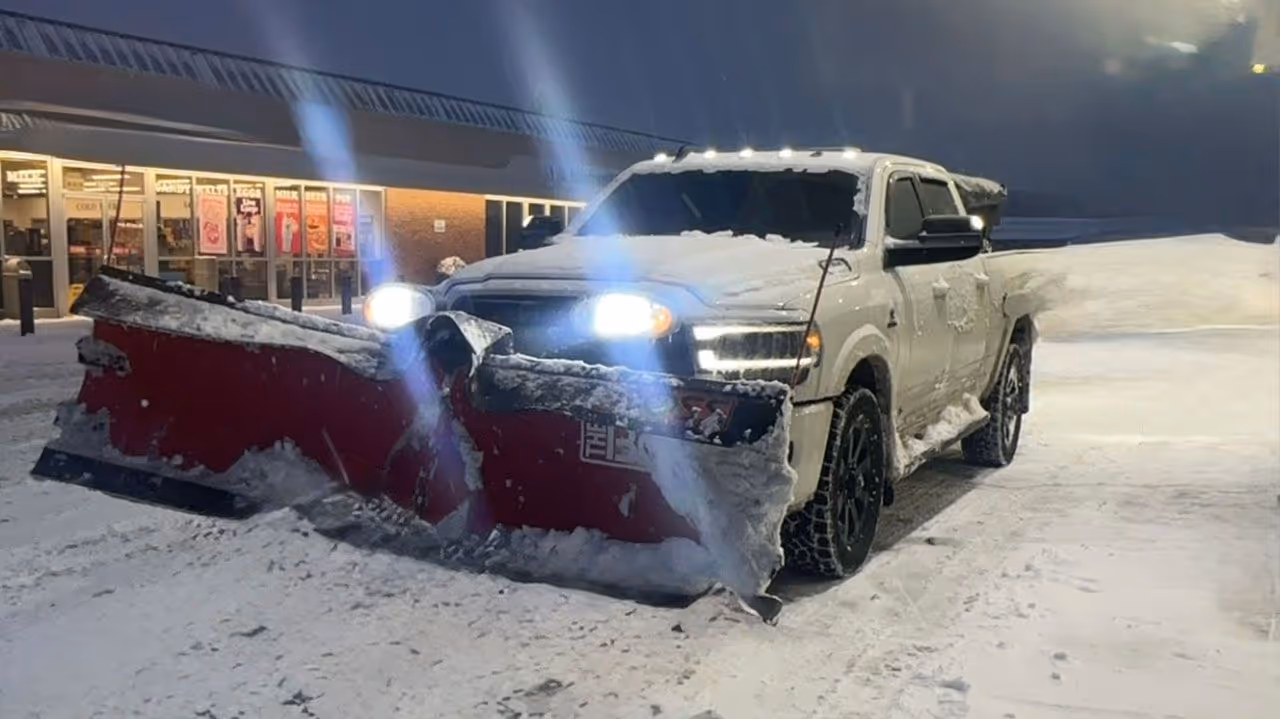 Triscapes snow plowing truck clearing residential driveway near me