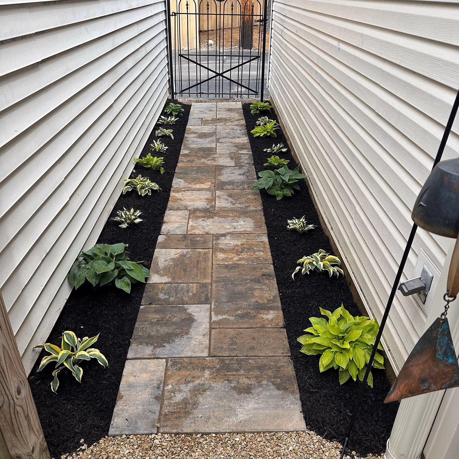 Mulch-lined walkway with clean paver edge professionally installed by Triscapes near me