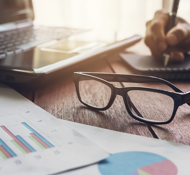 Birmingham SEO consultant workspace with analytics charts, laptop and glasses on wooden desk.