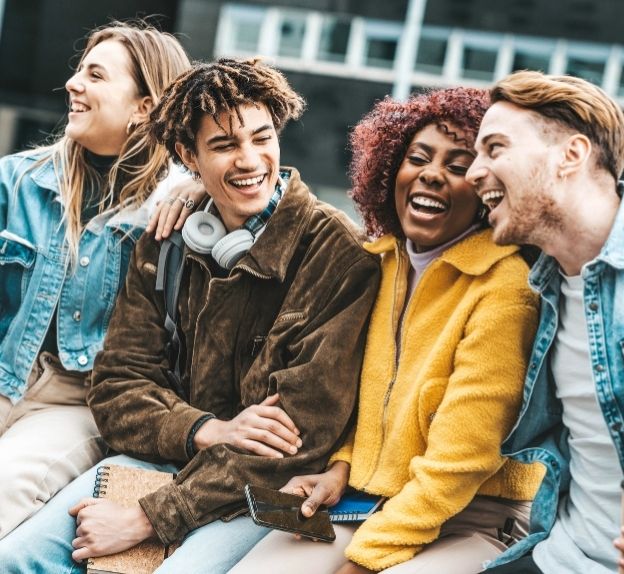 University of birmingham four students sitting together and smiling