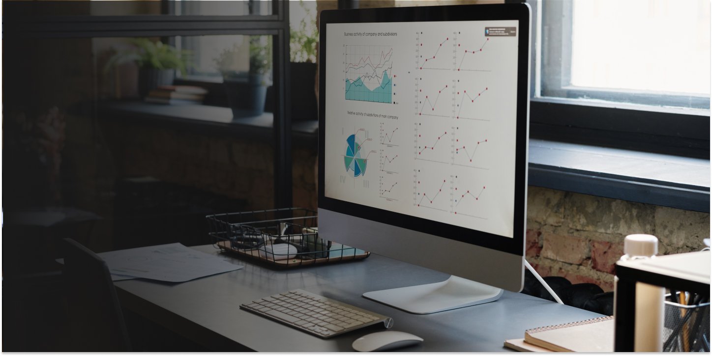 Workspace with desktop, monitor and keyboard on a wooden desk, ideal for planning SEO strategy efficiently.