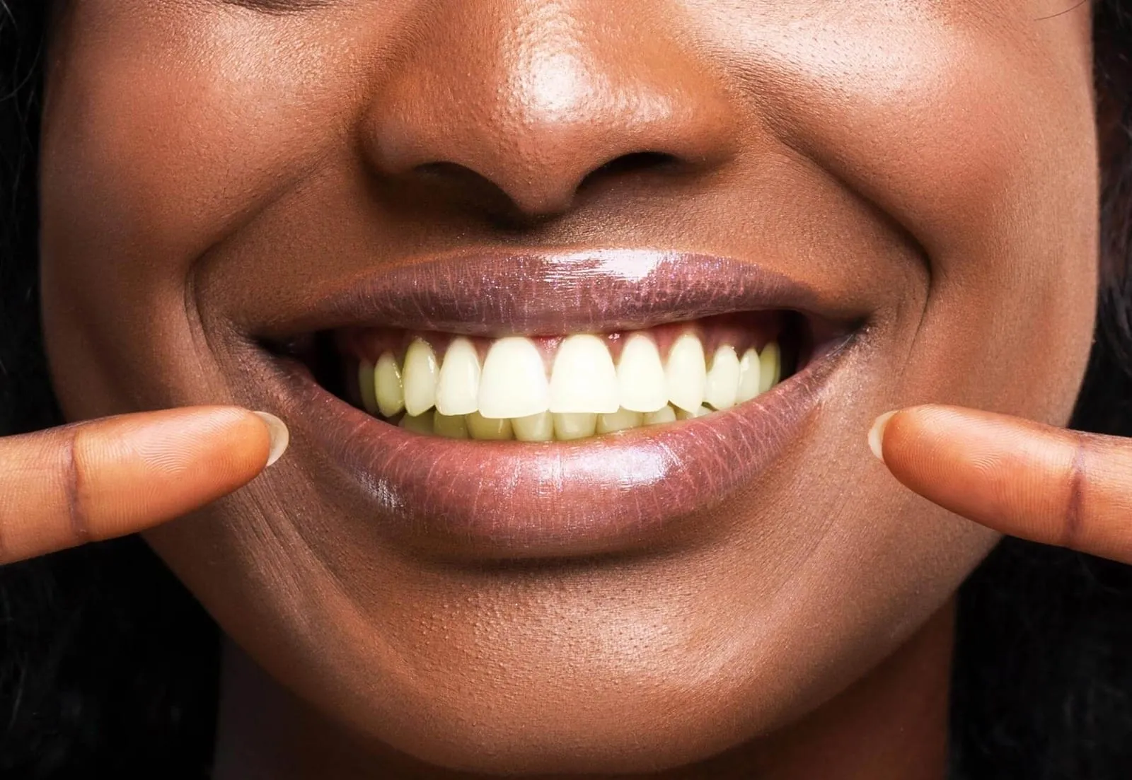 A close up of a woman's mouth with white teeth.
