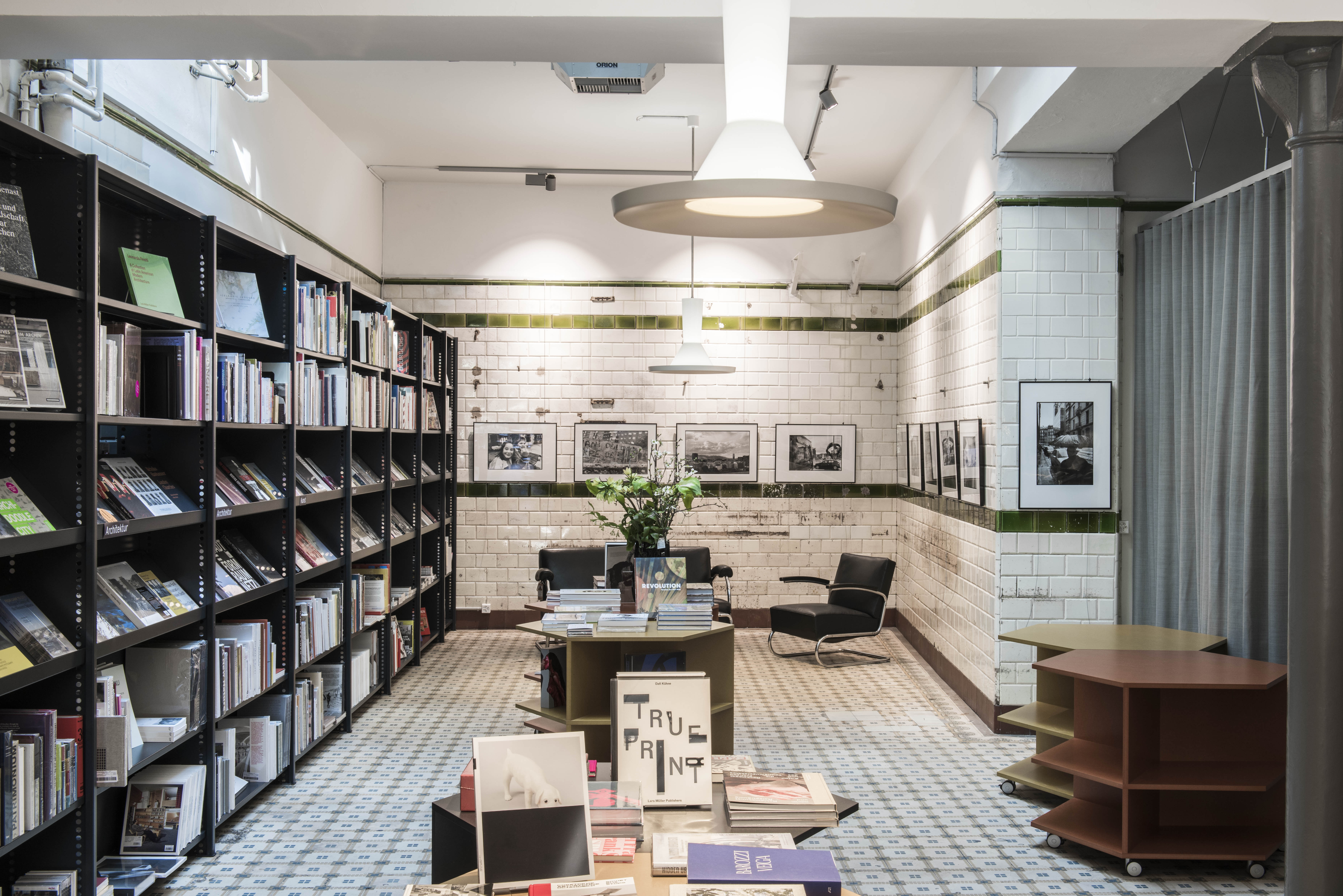 Ein älterer Herr steht vor einem grossen Bücherregal