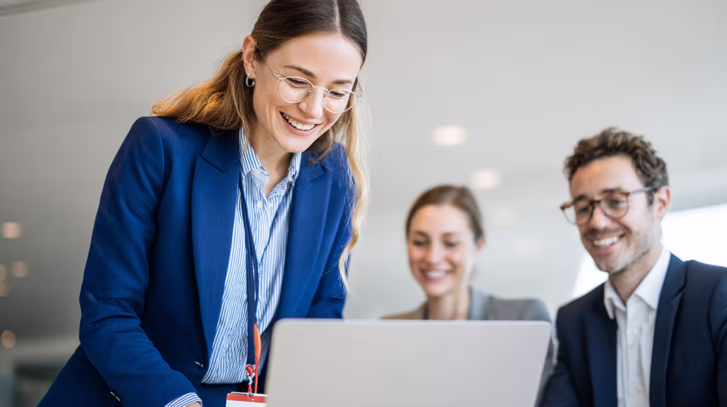 Smiling sales team comparing B2B prospecting software on a laptop