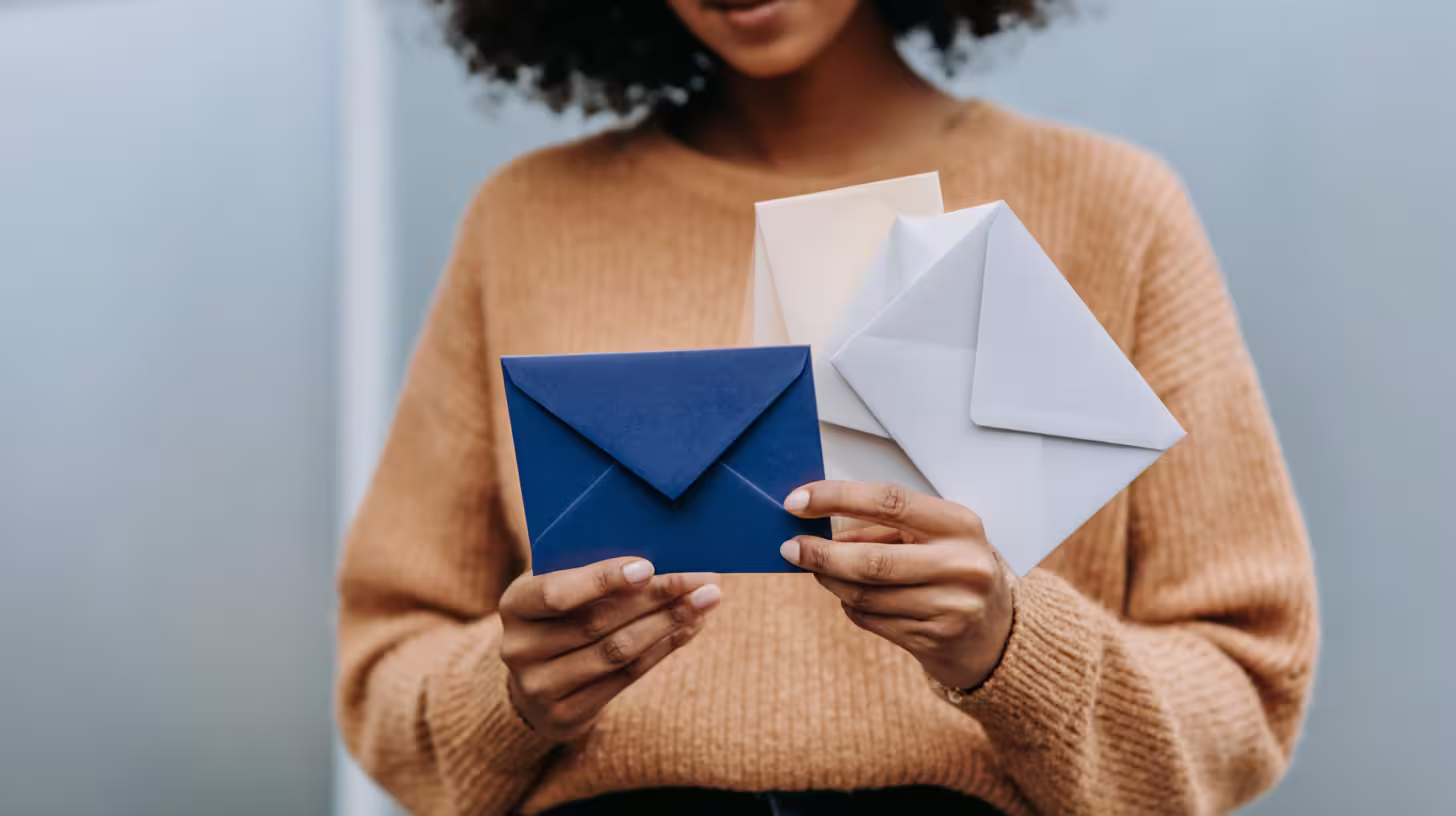 Woman holding several envelopes, illustrating the best time to send a prospecting email