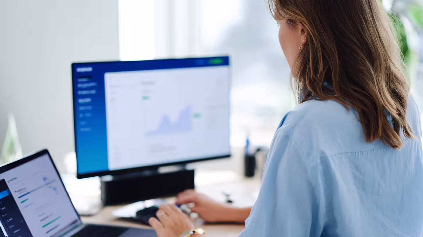 Woman analyzing prospecting dashboard charts on two screens