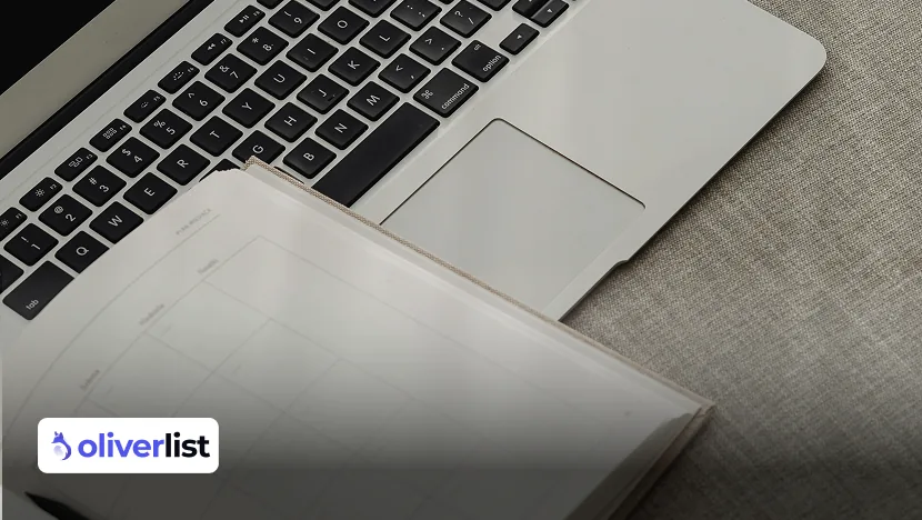 Laptop and open notebook on a desk for writing a sample customer record